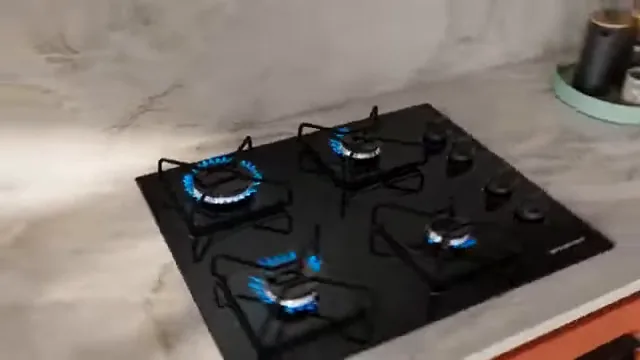 Quatro bocas do cooktop Brastemp funcionando simultaneamente com chamas azuis