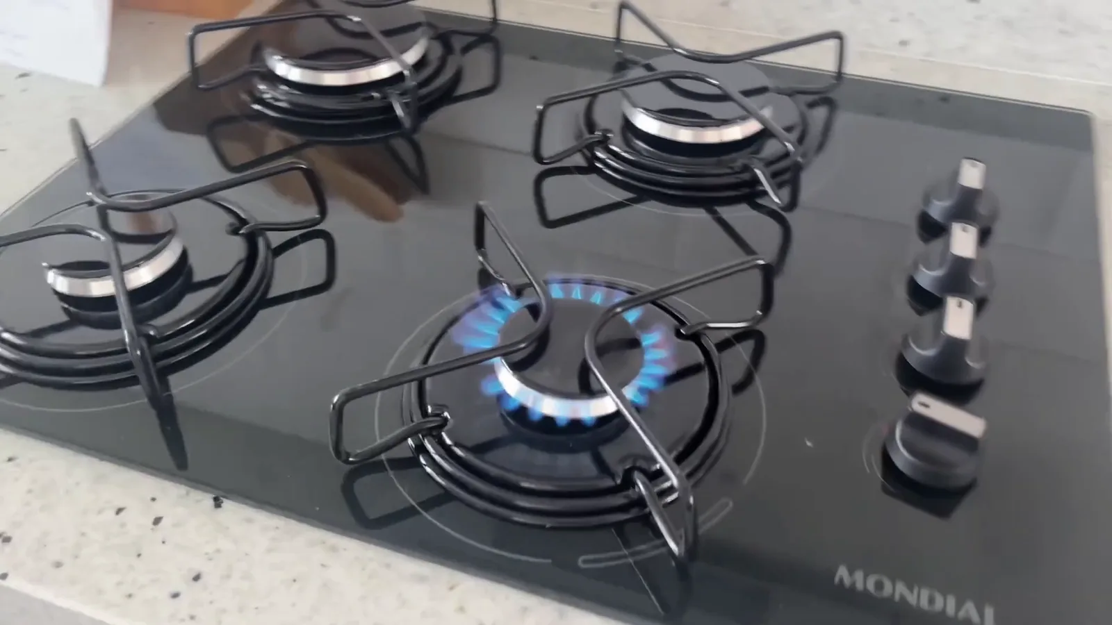 Cooktop com queimador aceso em funcionamento na bancada da cozinha