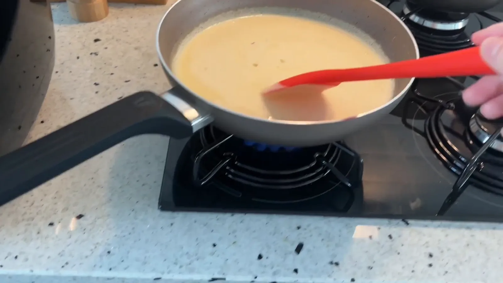 Preparo de alimentos em frigideira sobre o cooktop a gás