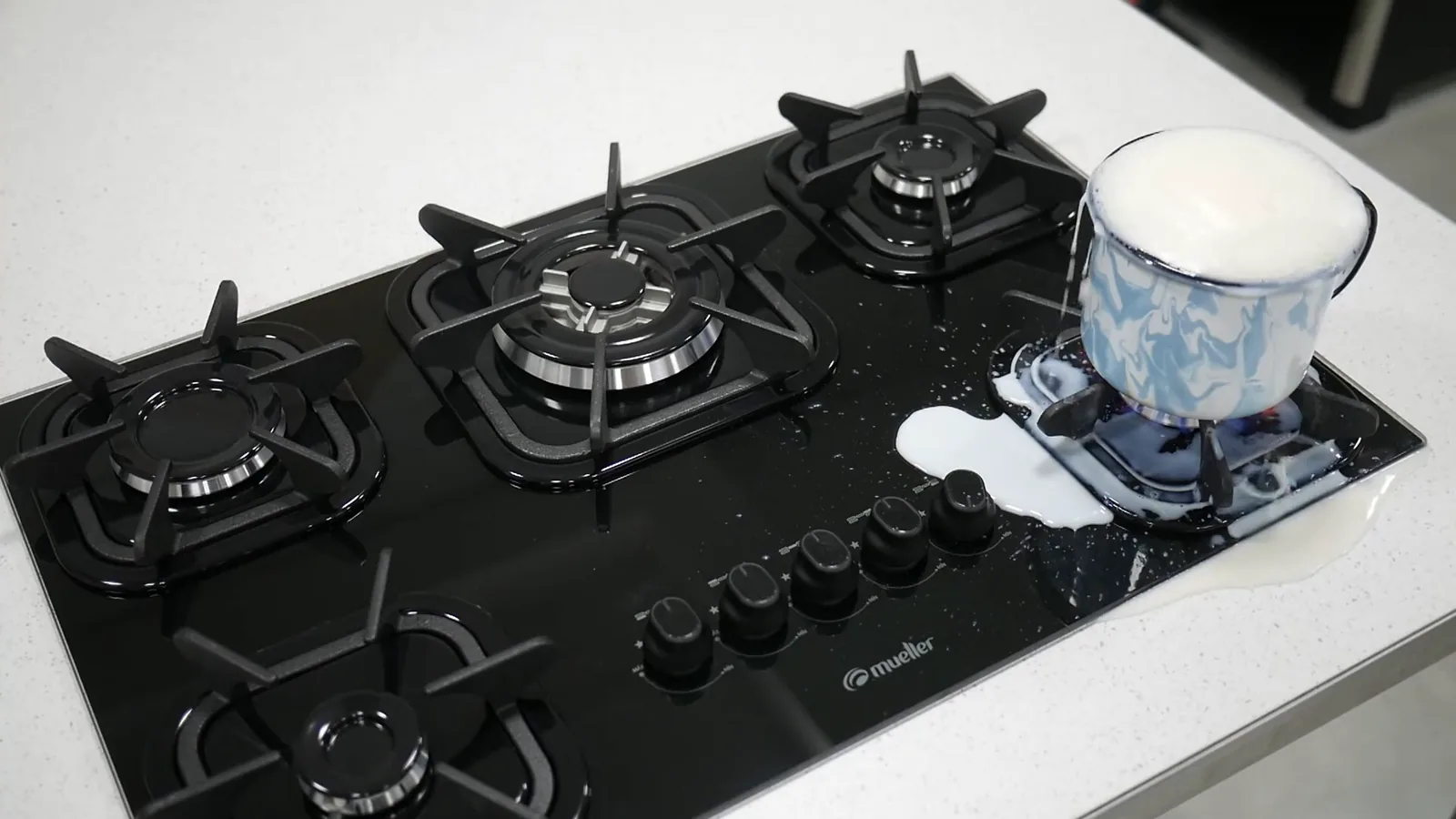 Leite fervendo e transbordando sobre a mesa de vidro do cooktop