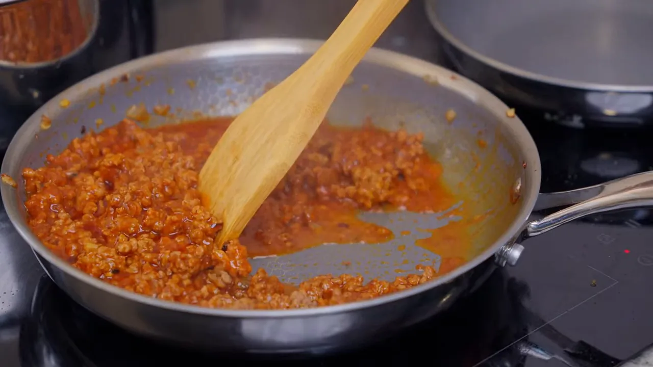 Molho bolonhesa sendo mexido durante o cozimento no cooktop Electrolux