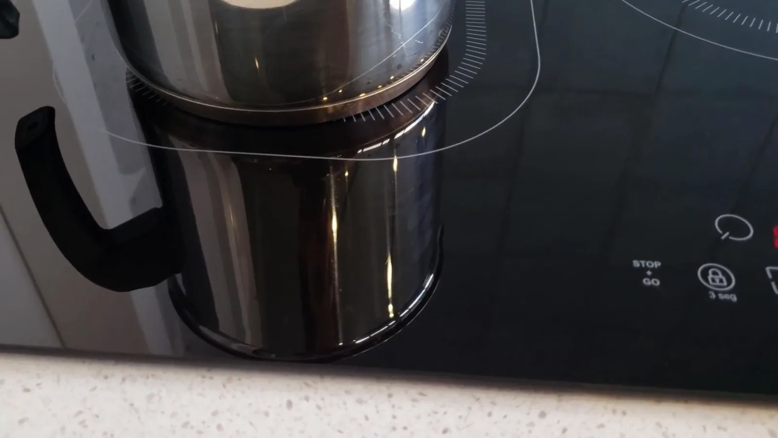 Panela de água fervendo sobre a zona de indução do cooktop