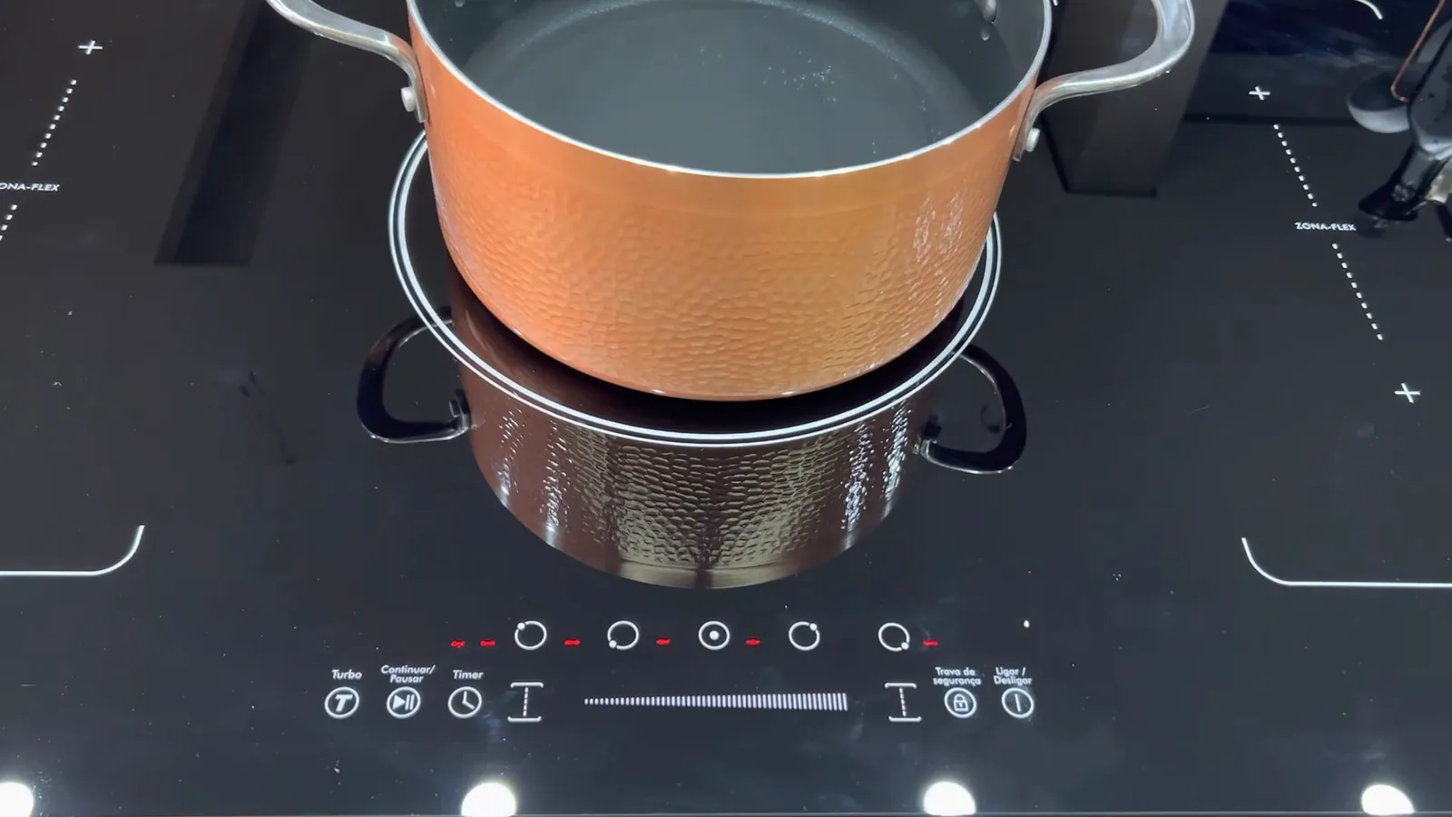 Cooktop Philco em funcionamento com panela sobre a zona central