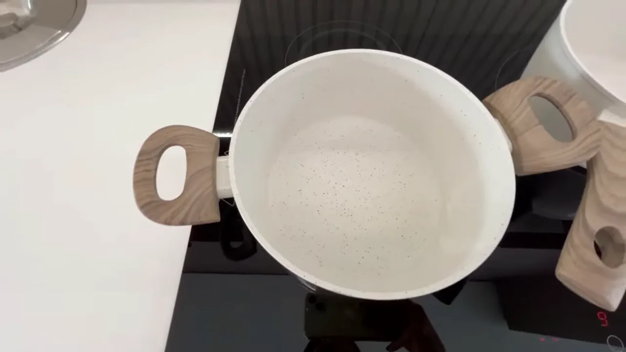 Água fervendo rapidamente na panela sobre o cooktop