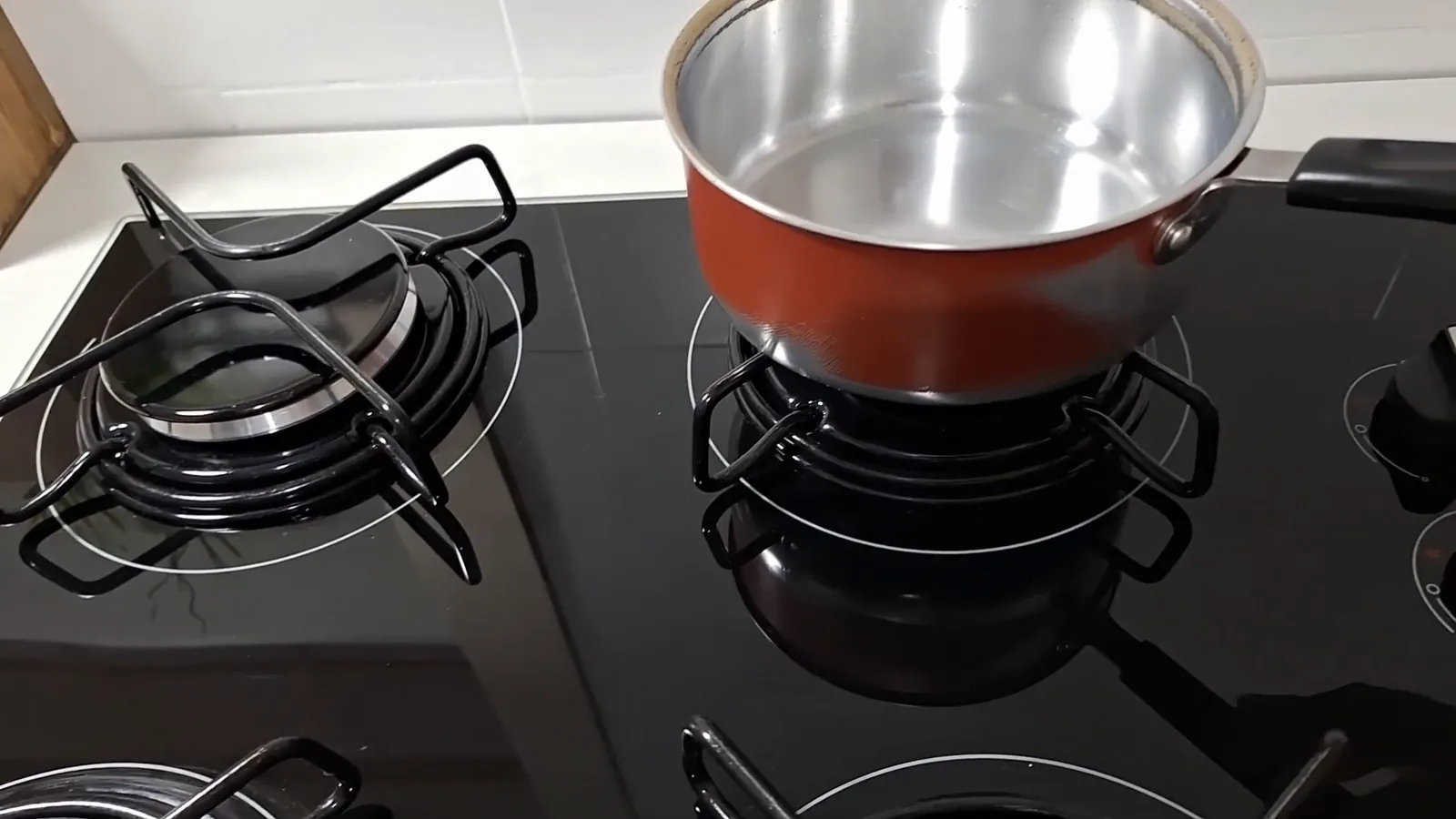 Panela pequena posicionada de forma segura na trempe do cooktop