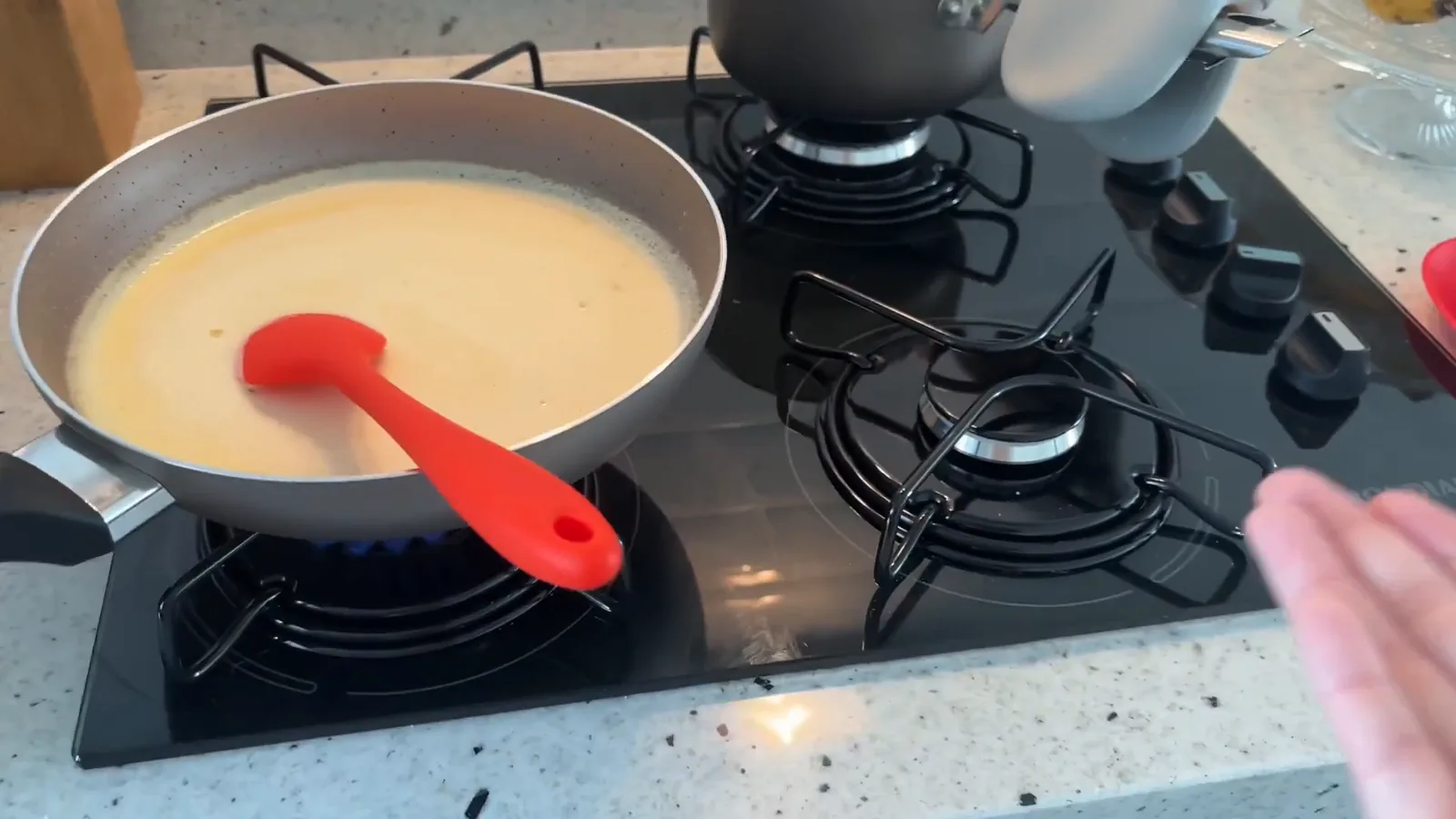Panelas em preparo nos queimadores do cooktop de vidro