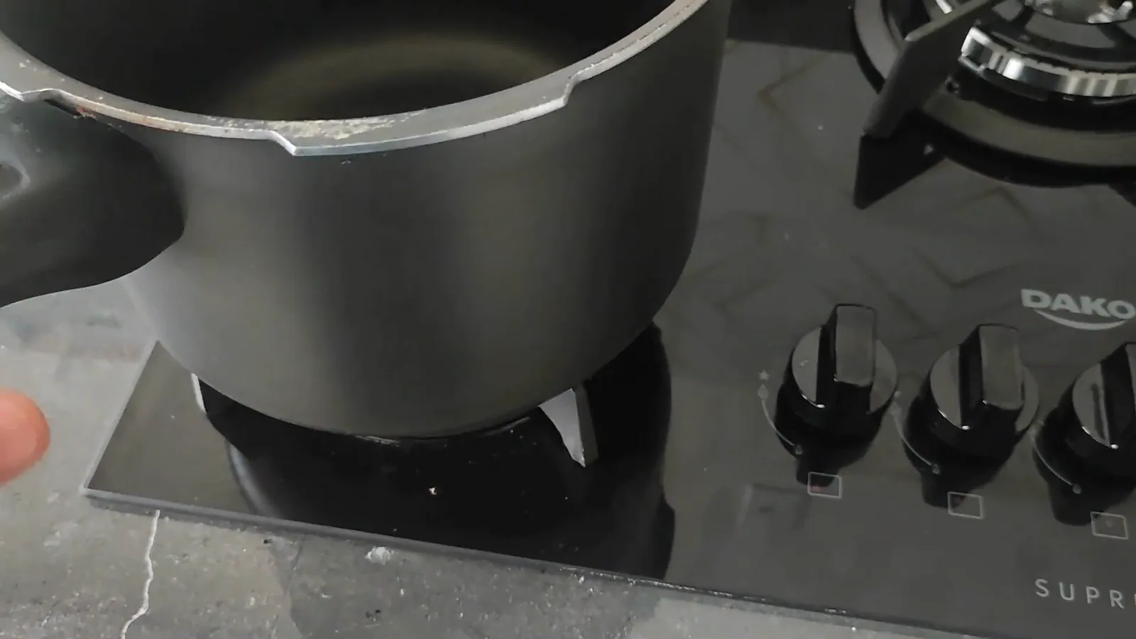 Panela pesada posicionada sobre a trempe de ferro fundido