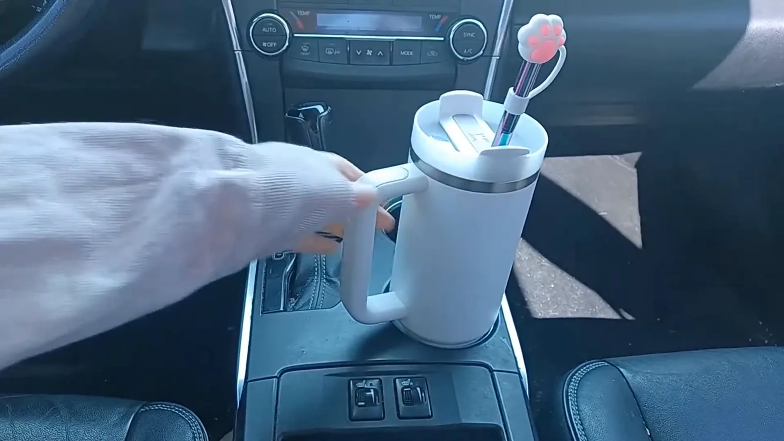 Copo térmico Stanley Quencher perfeitamente apoiado no porta-copos do carro