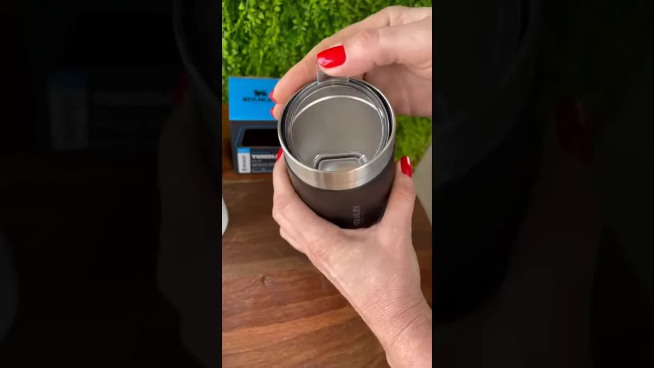 Tampa de Tritan com abertura fixa sendo manuseada no copo térmico