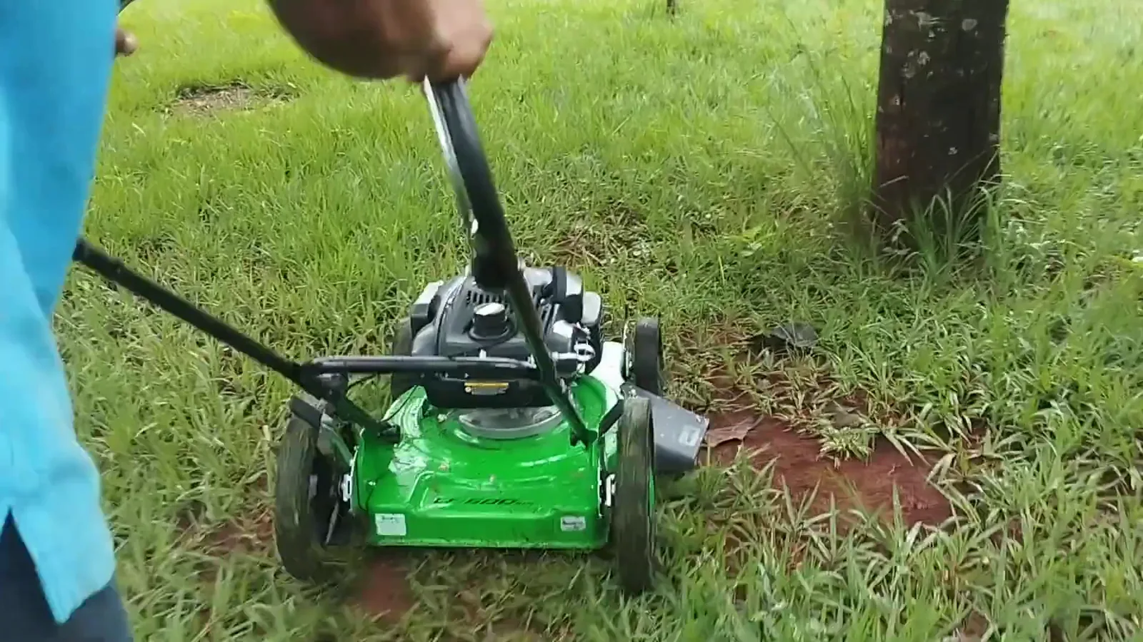 Operador conduzindo o cortador Trapp a gasolina pelo gramado amplo