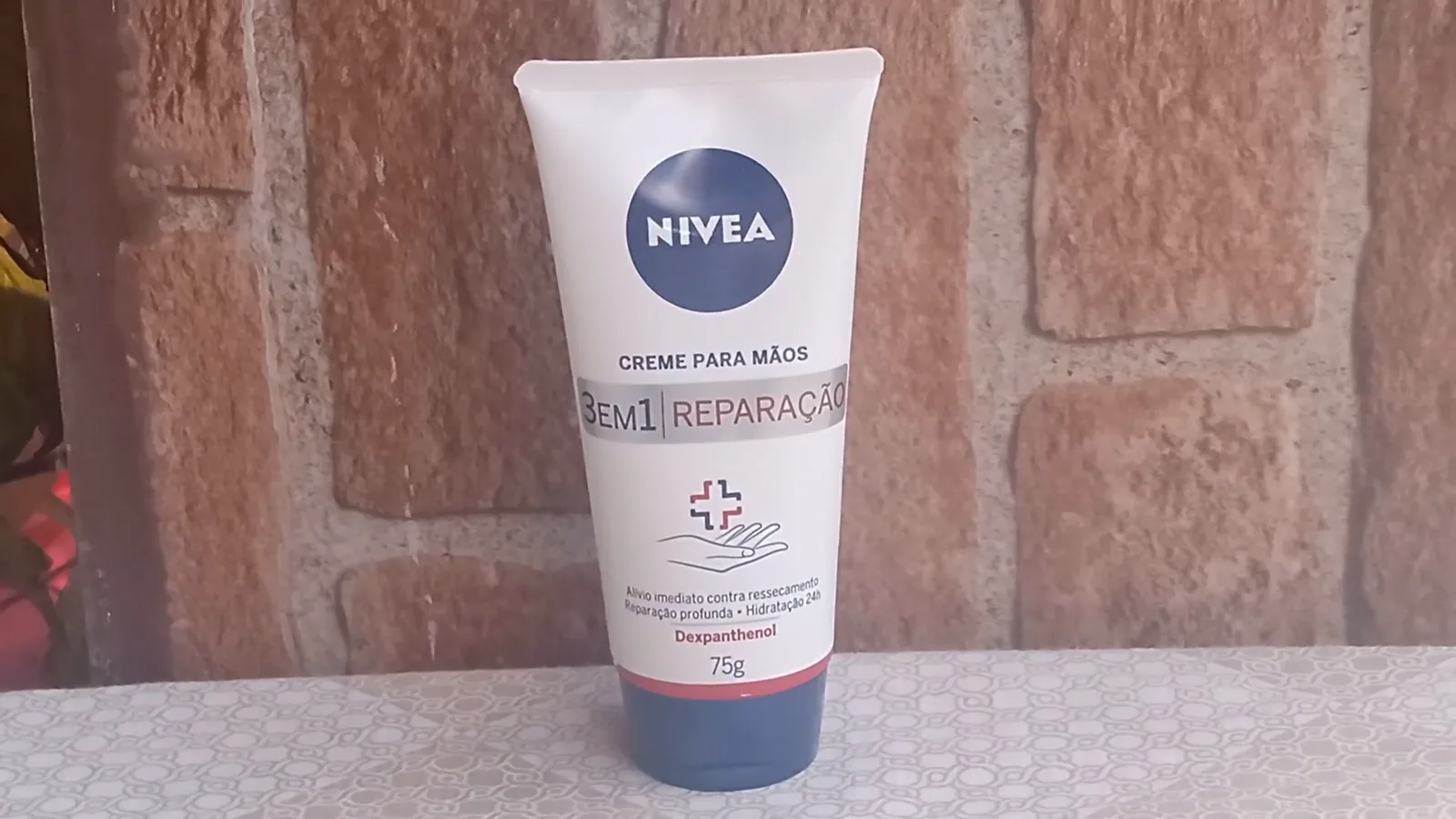 Bisnaga de creme Nivea 3 em 1 Reparação apoiada sobre a mesa