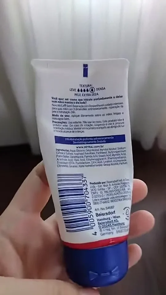 Manuseio da embalagem do creme Nivea mostrando informações no verso