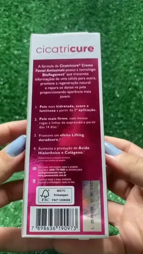 Manuseio da embalagem do creme Cicatricure exibindo detalhes no verso