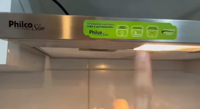 Depurador Philco com lâmpada integrada acesa sobre o fogão