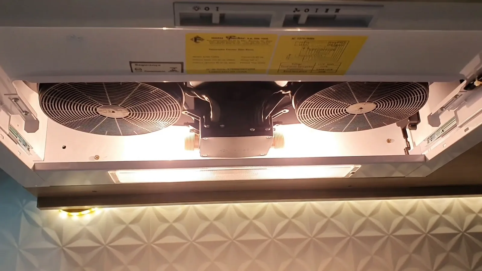 Interior do depurador aberto exibindo os motores e lâmpadas incandescentes