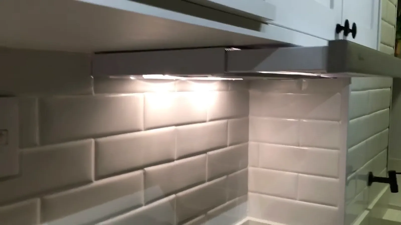 Depurador slim embutido aberto com iluminação acesa sob armário