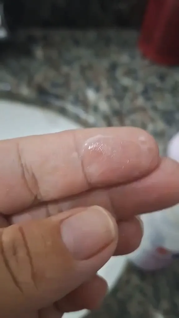 Textura líquida da emulsão antitranspirante NIVEA aplicada nos dedos