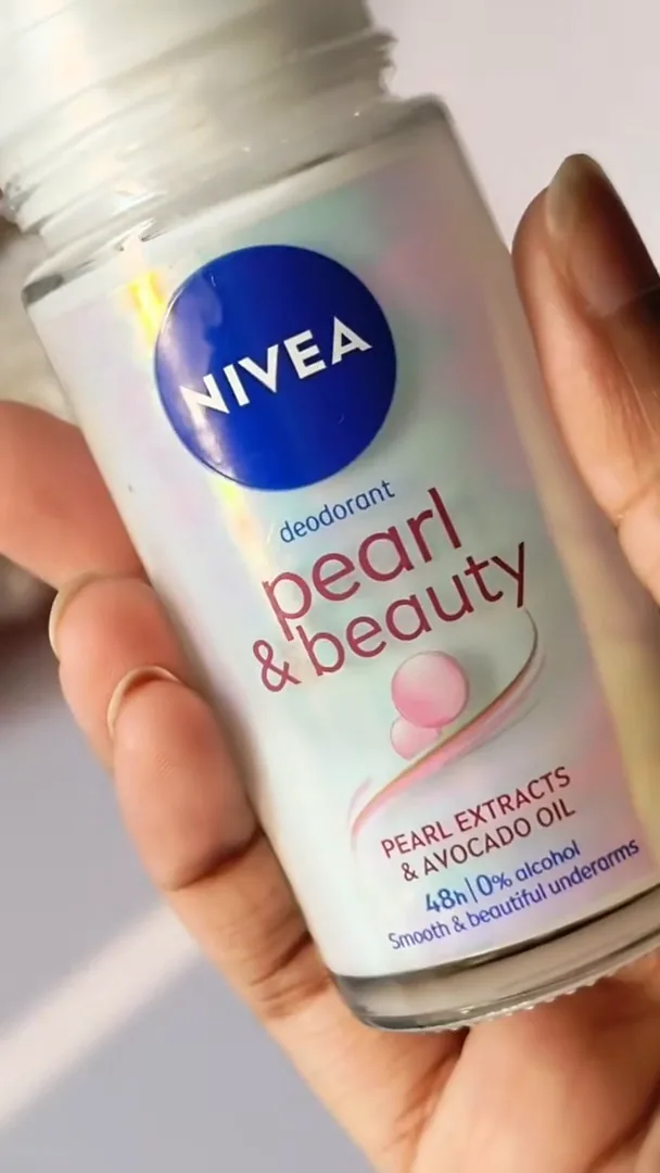 Frasco do desodorante roll-on NIVEA Pearl & Beauty segurado pelas mãos