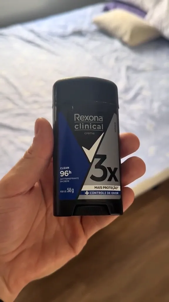 Embalagem frontal do desodorante Rexona Clinical Clean segurada na mão