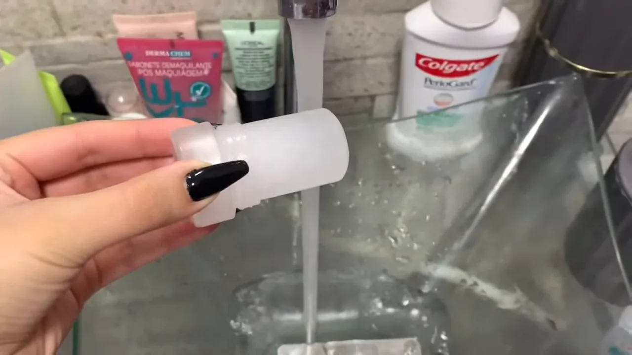 Umedecendo o stick de cristal sob água corrente da torneira