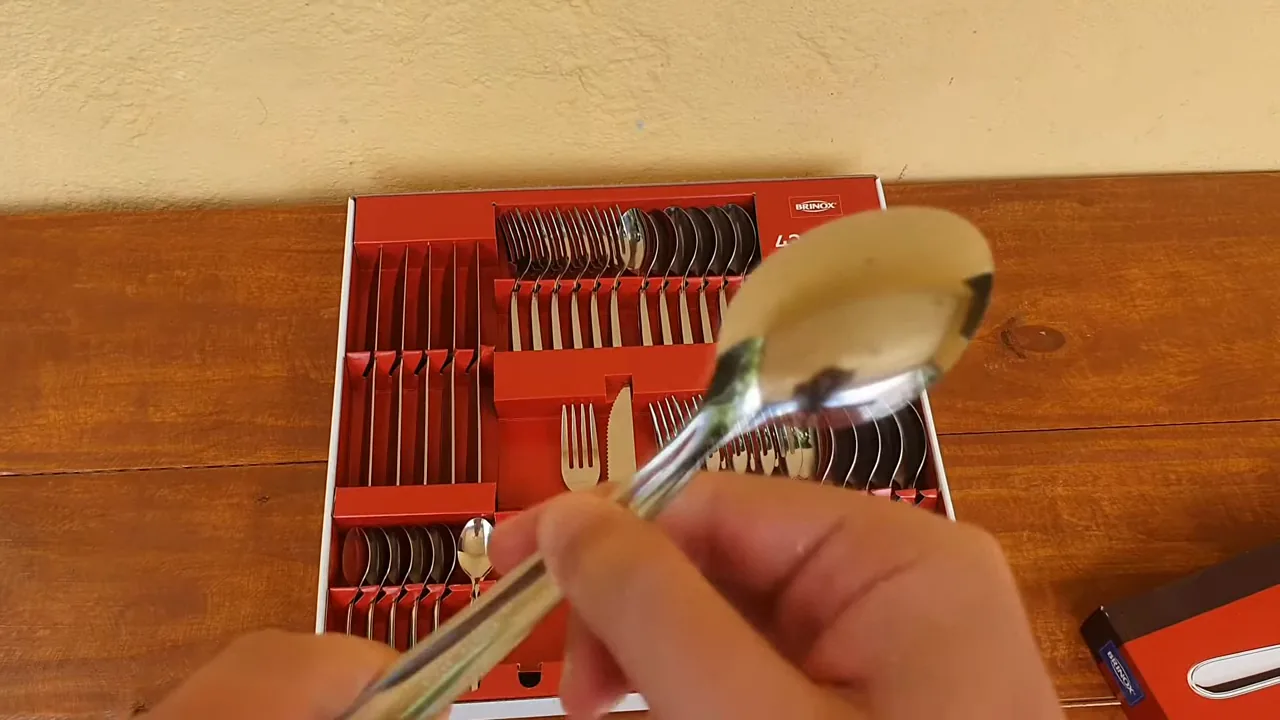 Manuseio da colher de aço inox para demonstrar o acabamento