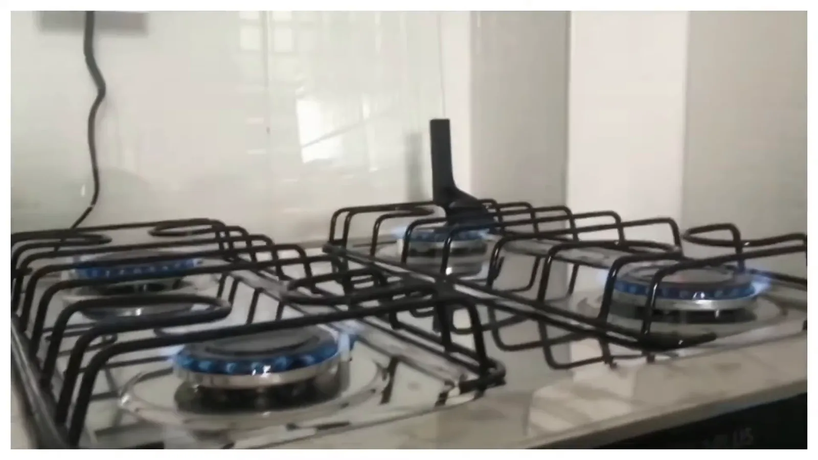 Queimadores acesos com chama constante na mesa de inox do fogão
