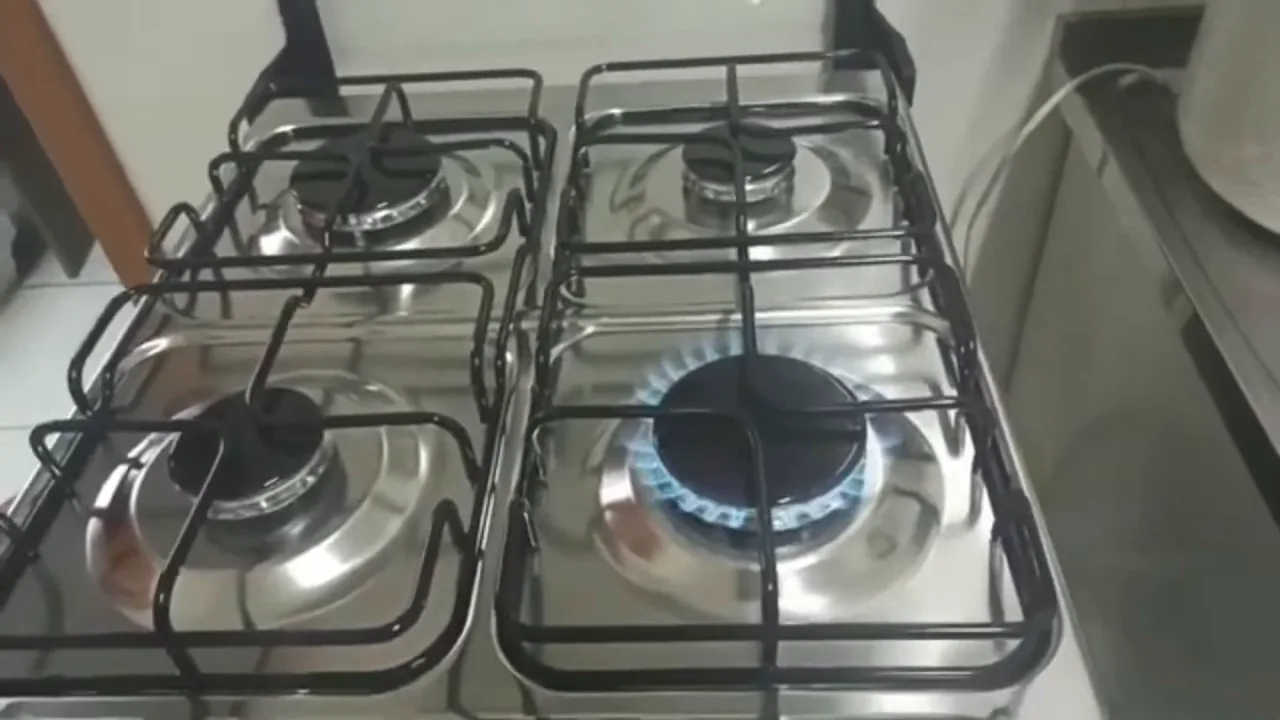 Acendimento da chama do queimador no fogão de quatro bocas