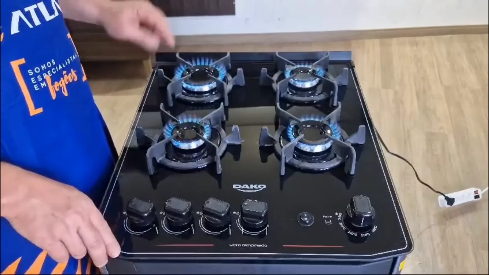 Mesa de vidro com quatro queimadores acesos em chamas azuis