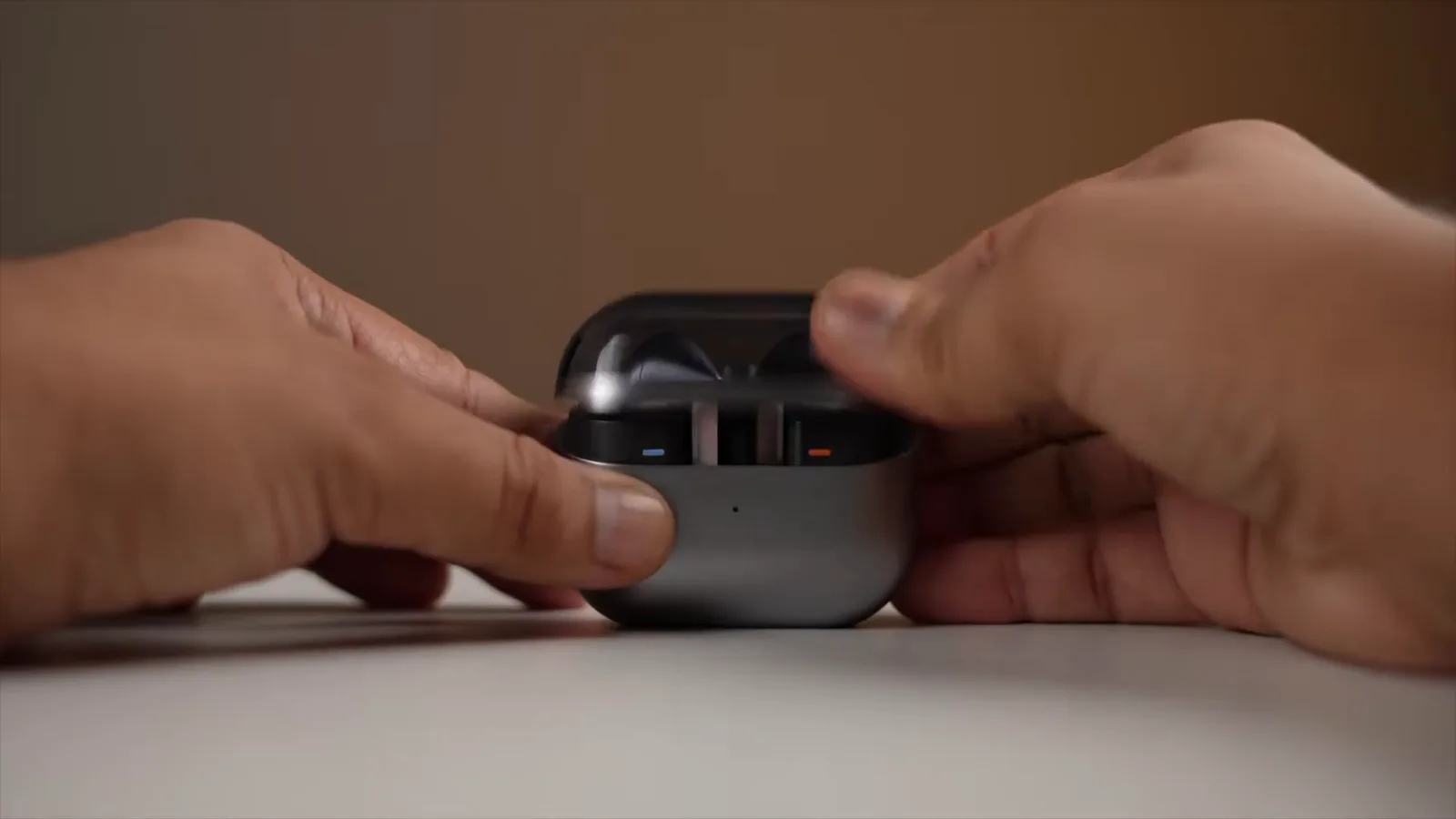 Estojo aberto com fones e indicador LED em funcionamento