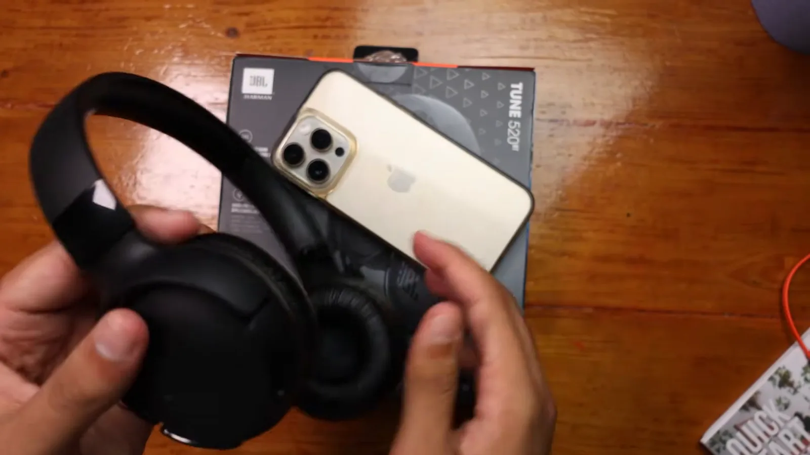 Fone de ouvido JBL Tune 520BT segurado pelas mãos com headband flexível