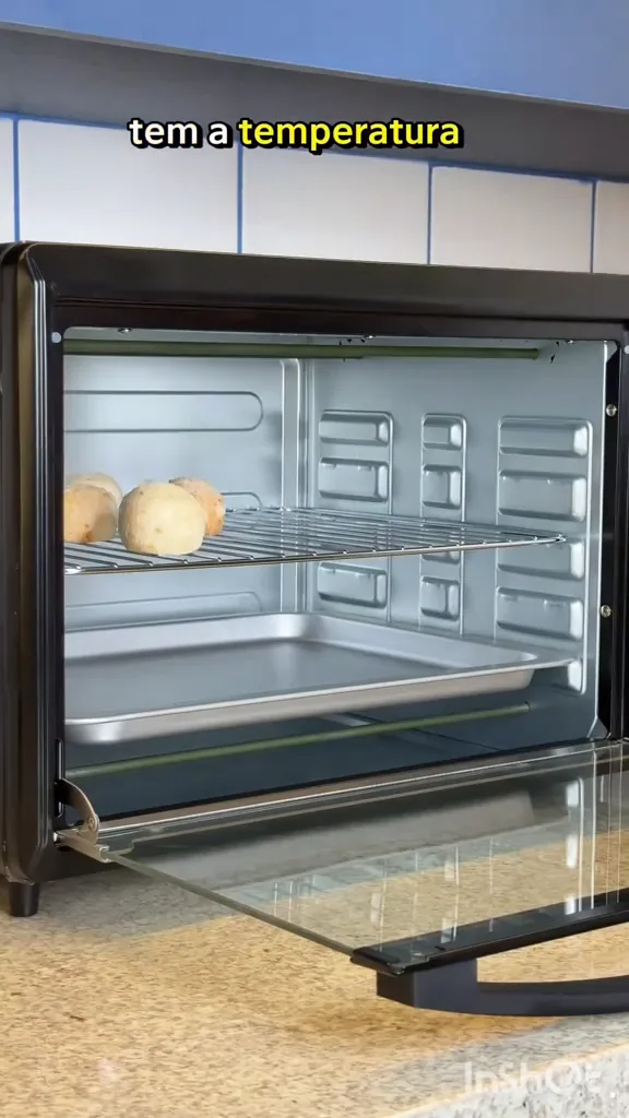 Forno elétrico com pães de queijo distribuídos na grelha interna