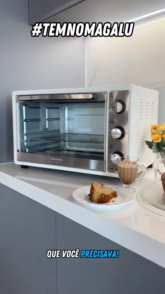 Forno elétrico Mondial acomodado na bancada ao lado de bolo assado