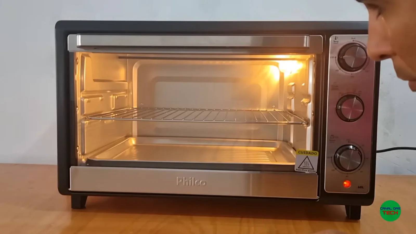 Forno elétrico Philco ligado com iluminação interna acesa em bancada