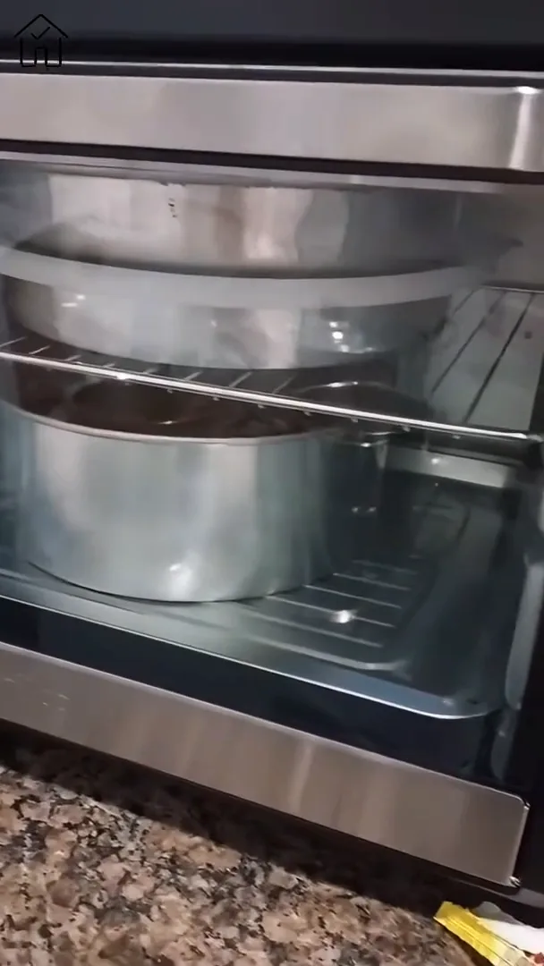 Forno elétrico com formas de bolo assando através do visor transparente