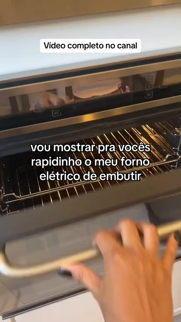Porta do forno elétrico aberta exibindo espaço interno e grades
