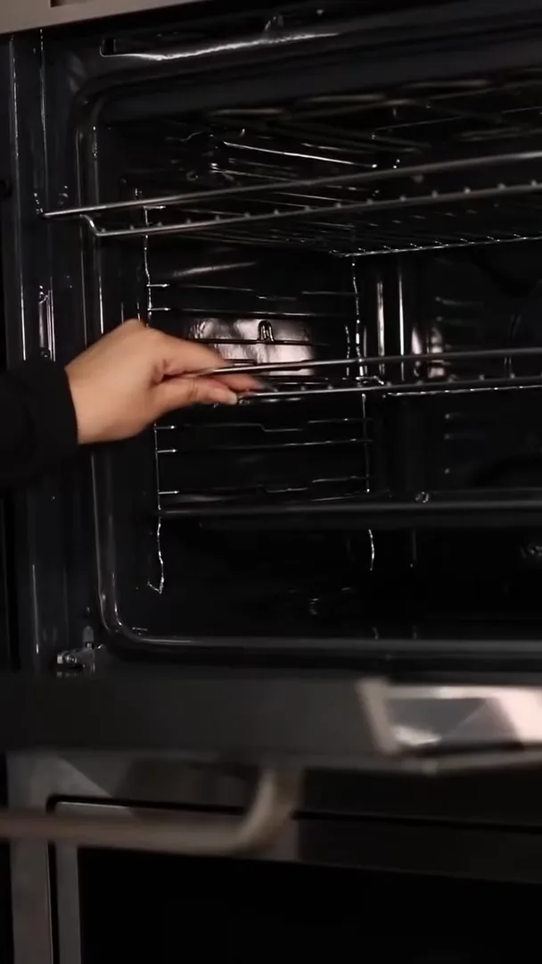 Grade ajustável deslizando pelos trilhos na cavidade interna do forno
