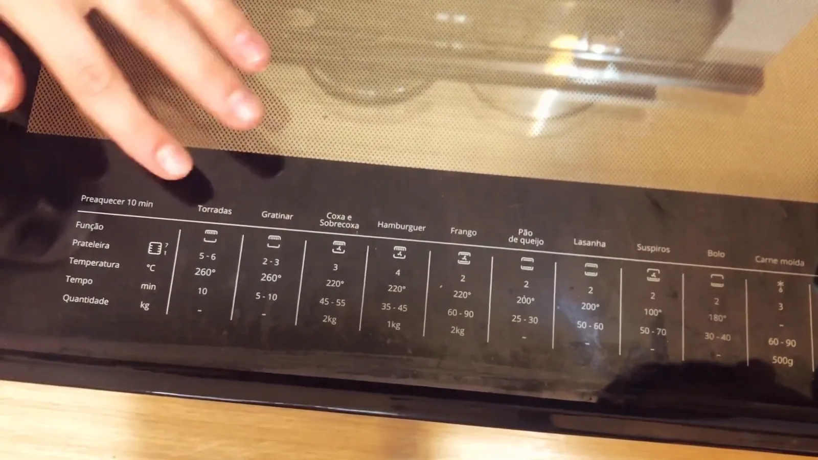 Guia impresso na porta com tempos e temperaturas de preparo