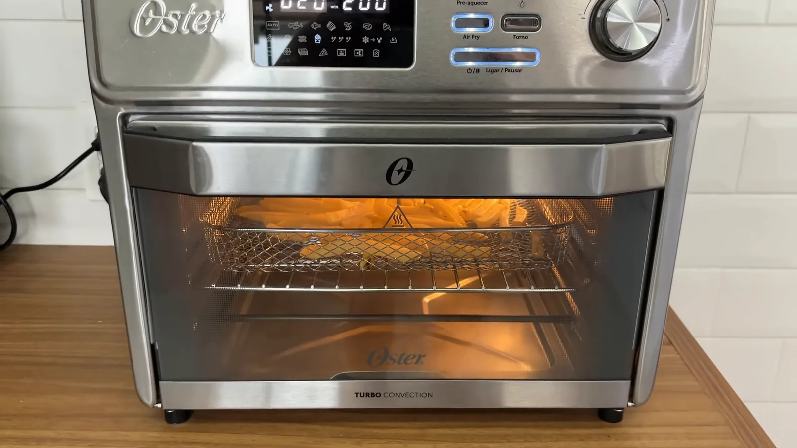 Forno elétrico Oster funcionando no modo fritadeira com luz interna