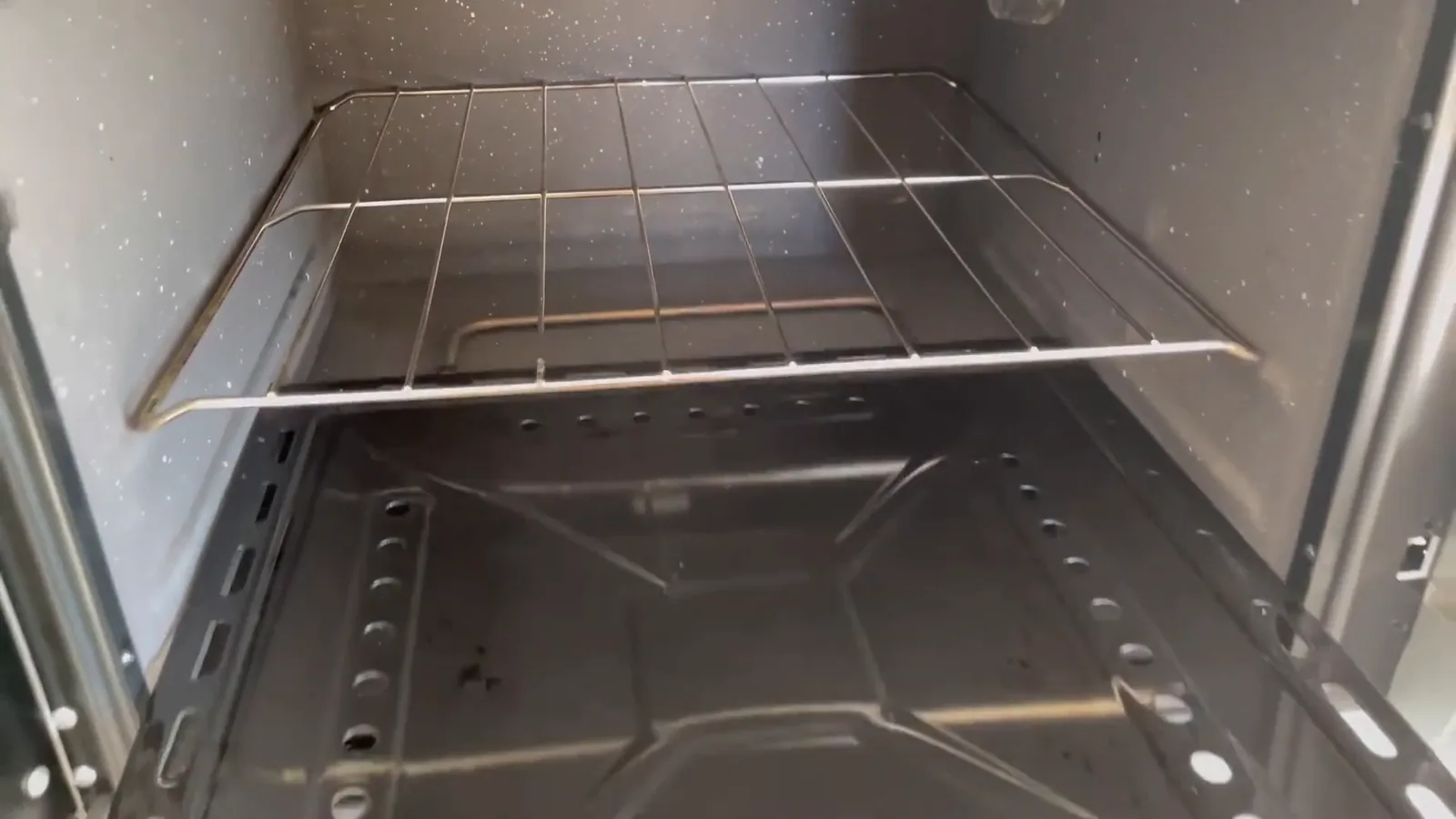 Bandeja coletora de resíduos esmaltada sendo removida do interior do forno elétrico