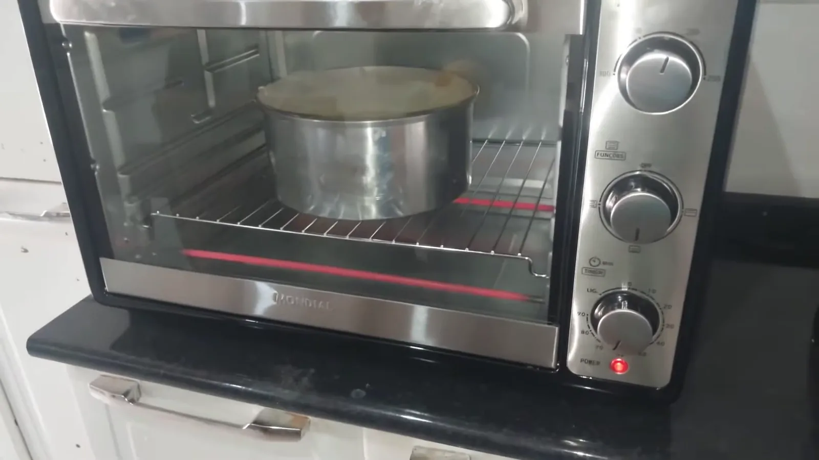 Forno elétrico Mondial assando bolo com resistência inferior aquecida