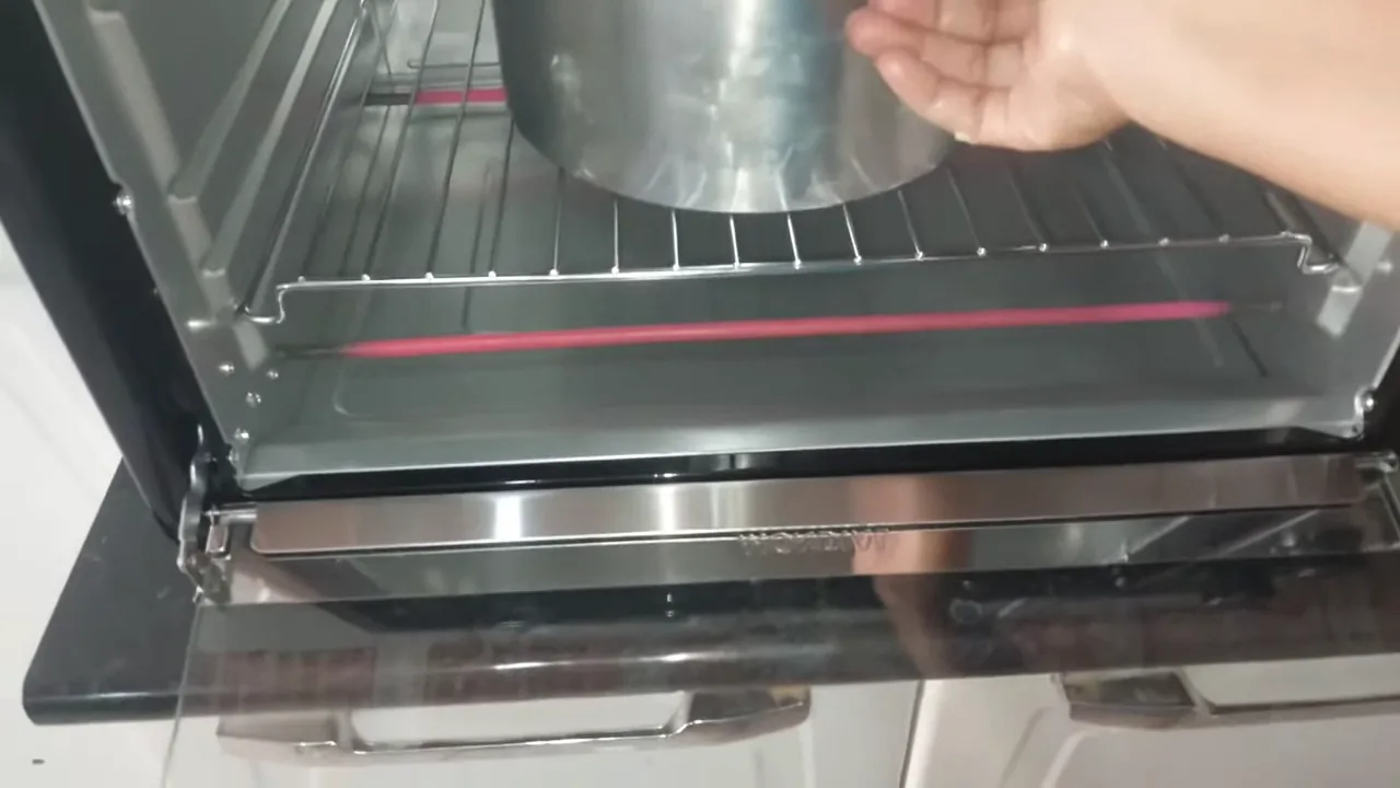 Inserção da forma de bolo no forno elétrico pré-aquecido