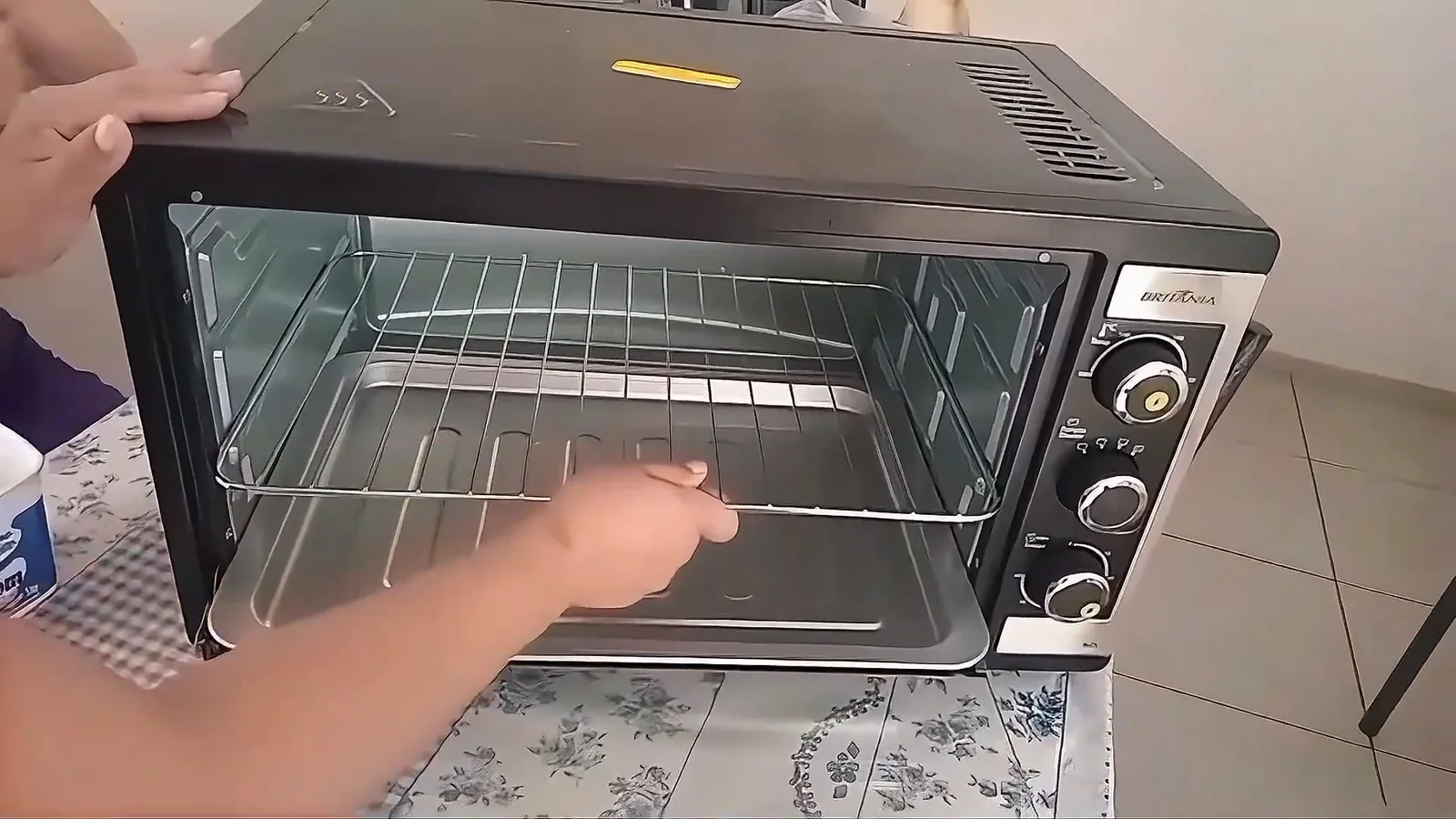 Grelha deslizante em inox sendo ajustada no forno elétrico