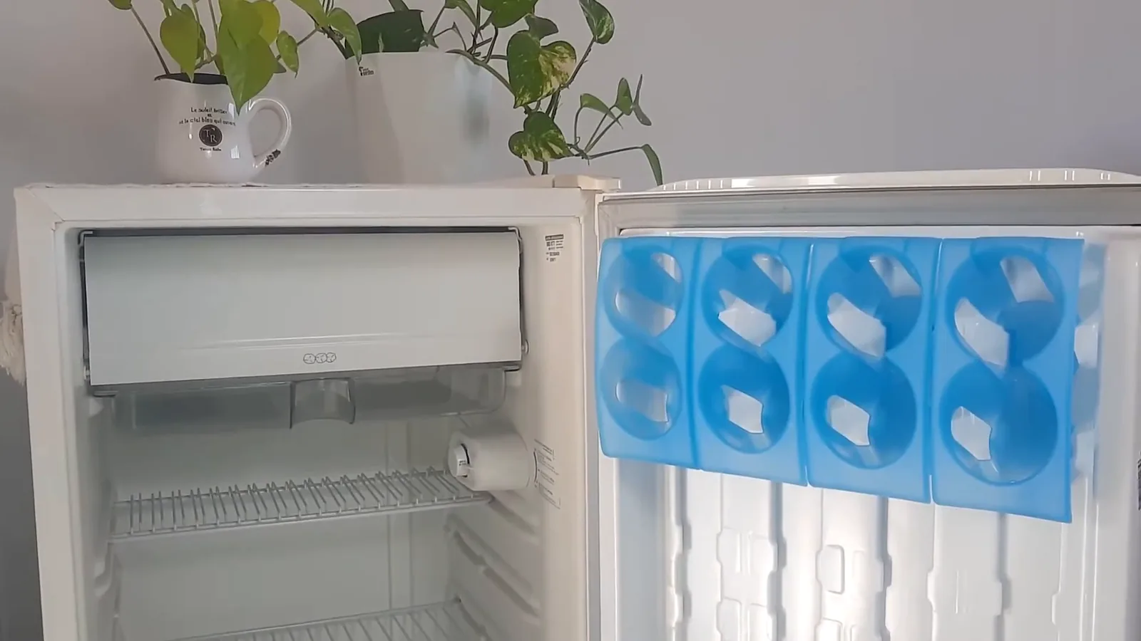 Frigobar aberto exibindo prateleiras internas e compartimentos modulares na porta