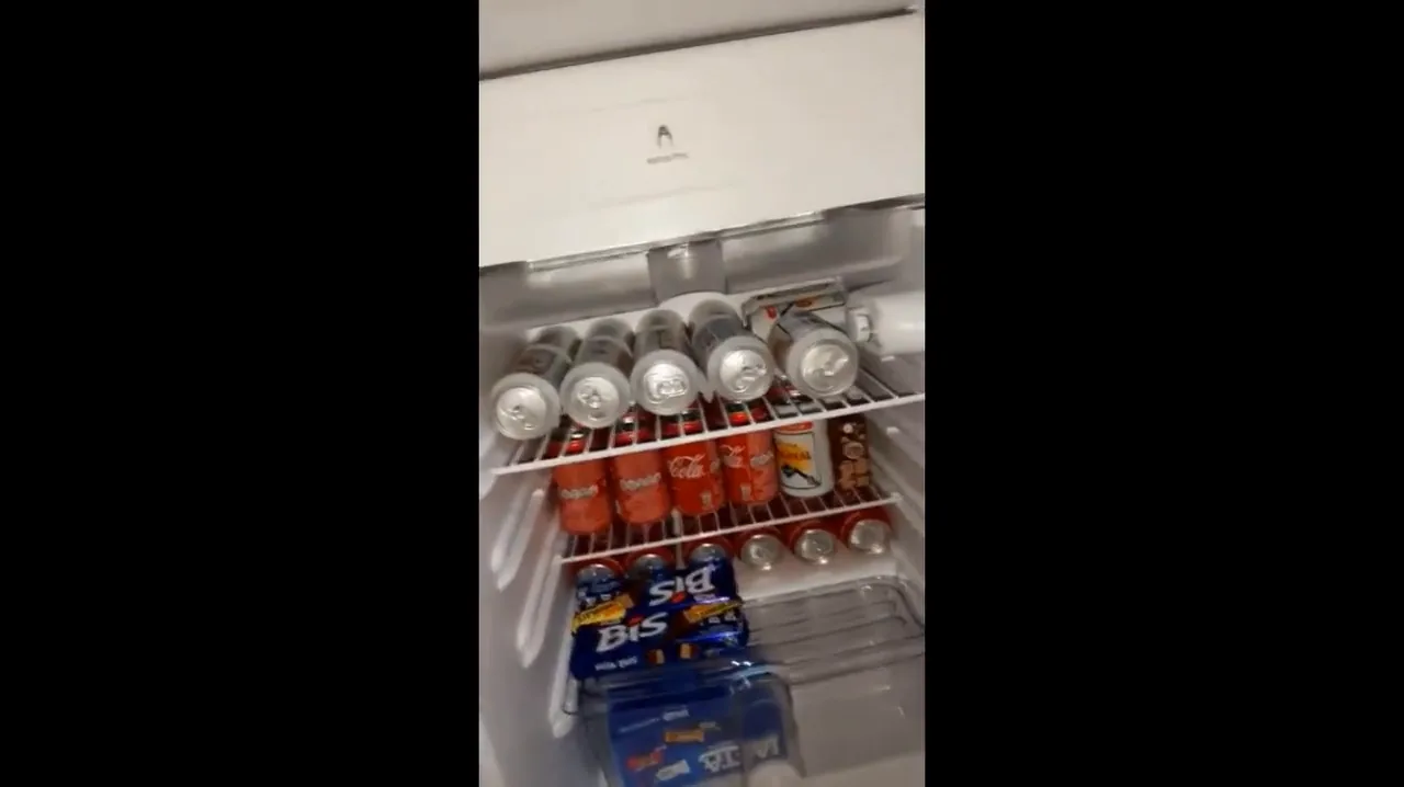 Frigobar Consul com prateleiras abastecidas de latinhas de cerveja e refrigerante