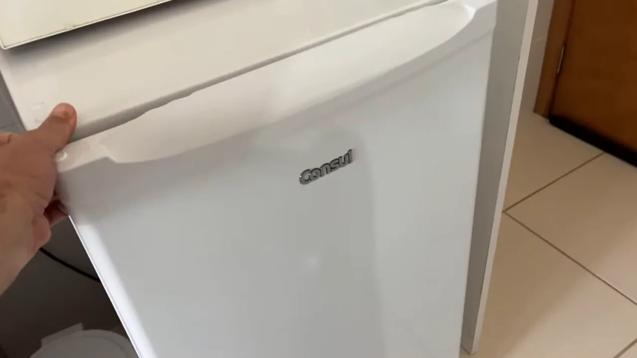 Abertura da porta revelando a organização interna do frigobar