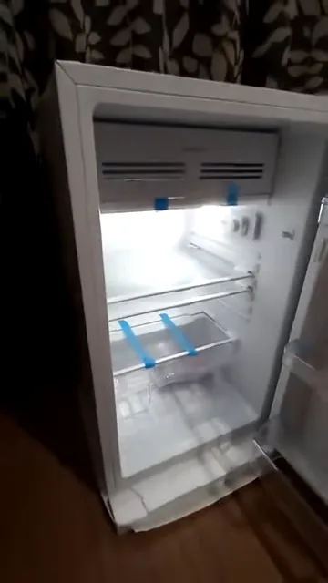 Interior iluminado do frigobar Electrolux com prateleiras e gaveta organizadora