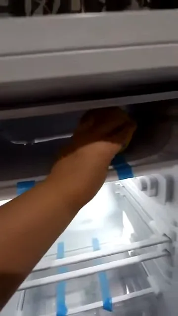 Inserindo garrafa de bebida no compartimento Cold Zone do frigobar