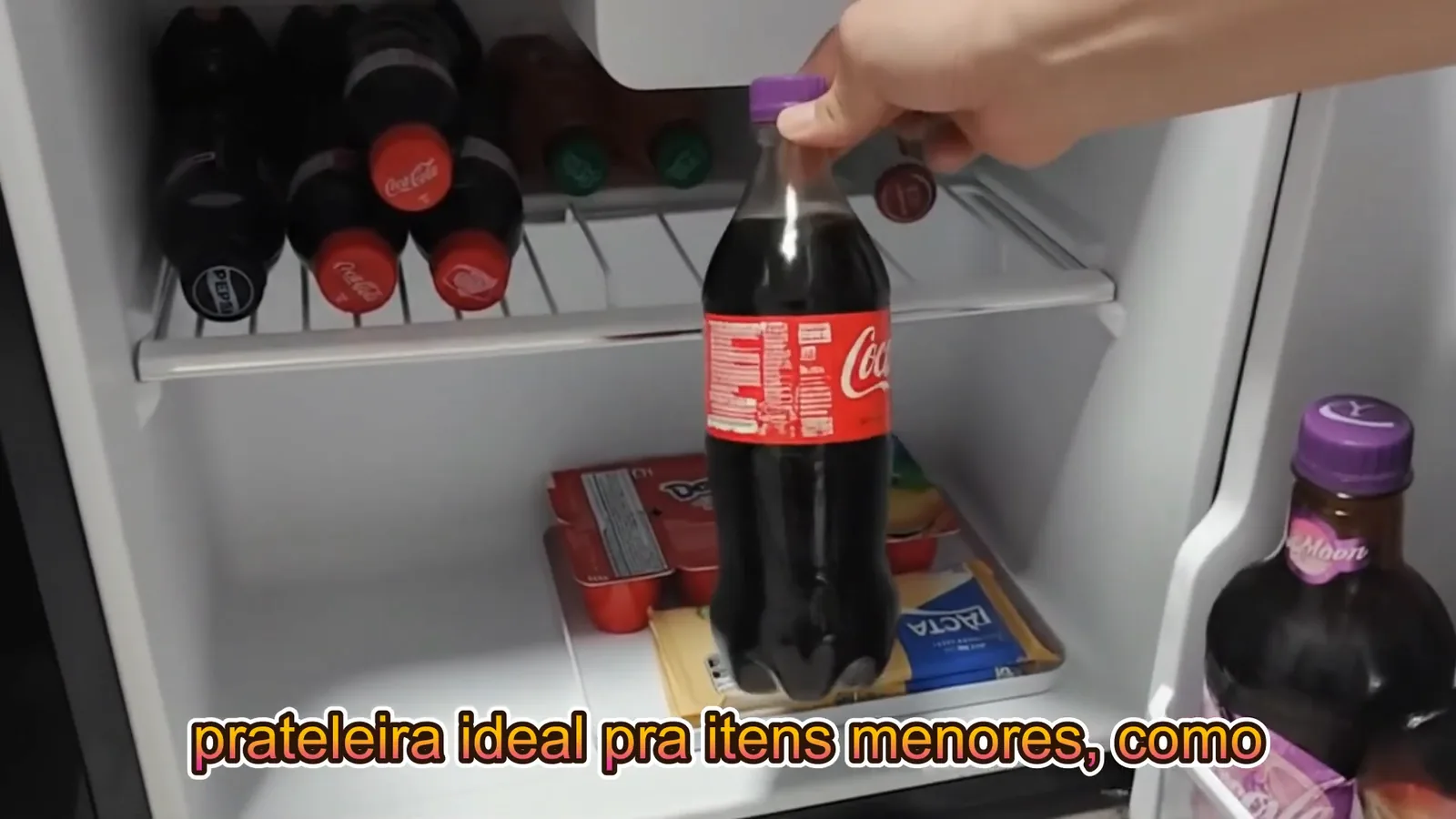 Garrafa de refrigerante e laticínios acomodados no frigobar Philco