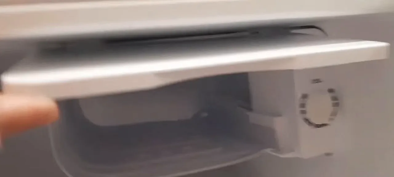 Porta do compartimento congelador do frigobar sendo aberta manualmente