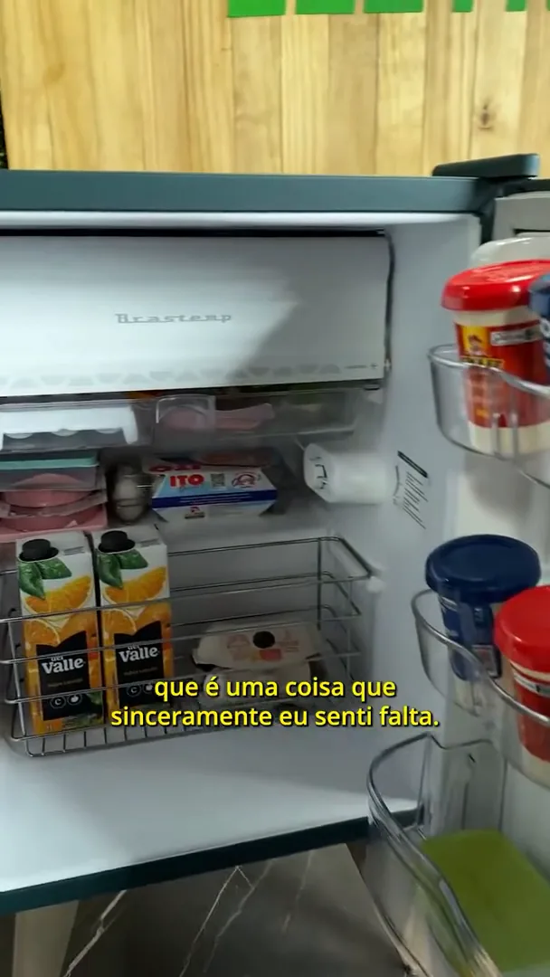 Espaço interno do frigobar abastecido com alimentos e congelador superior